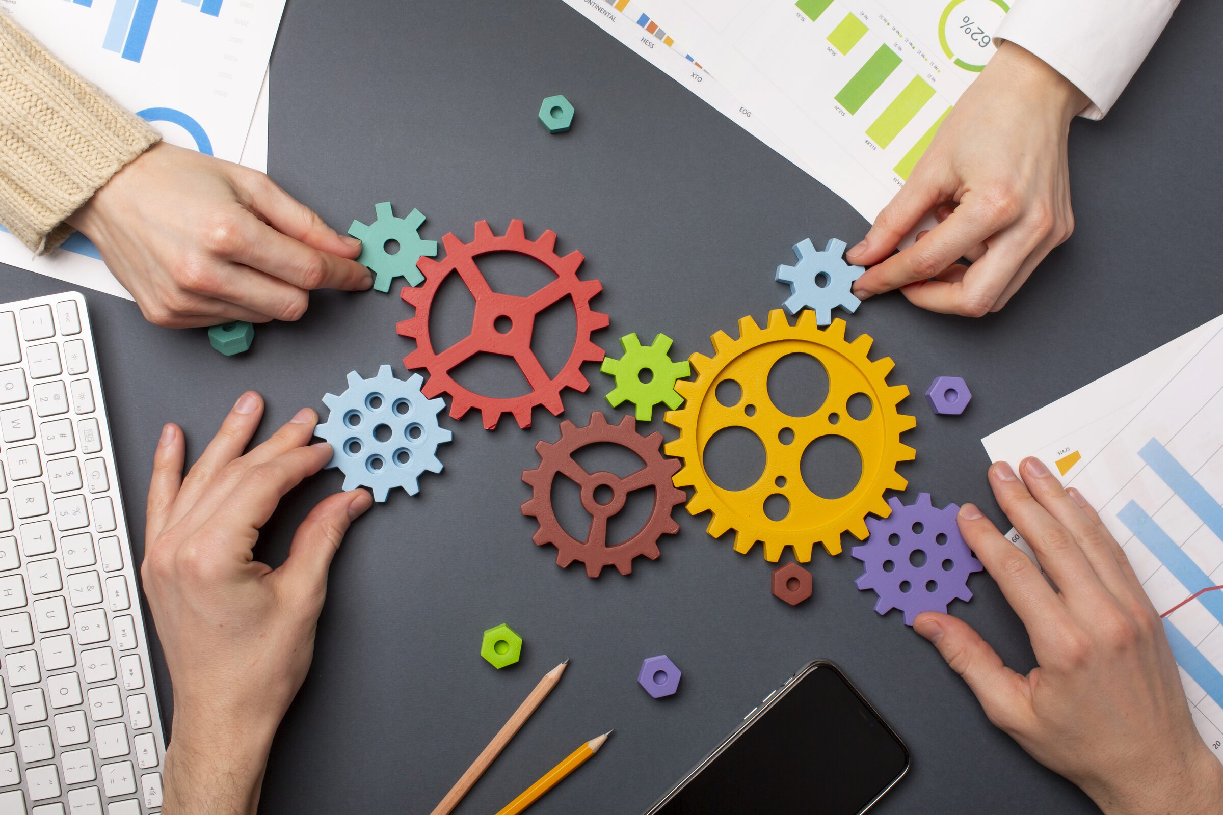 Hands arranging interconnected gears during process planning